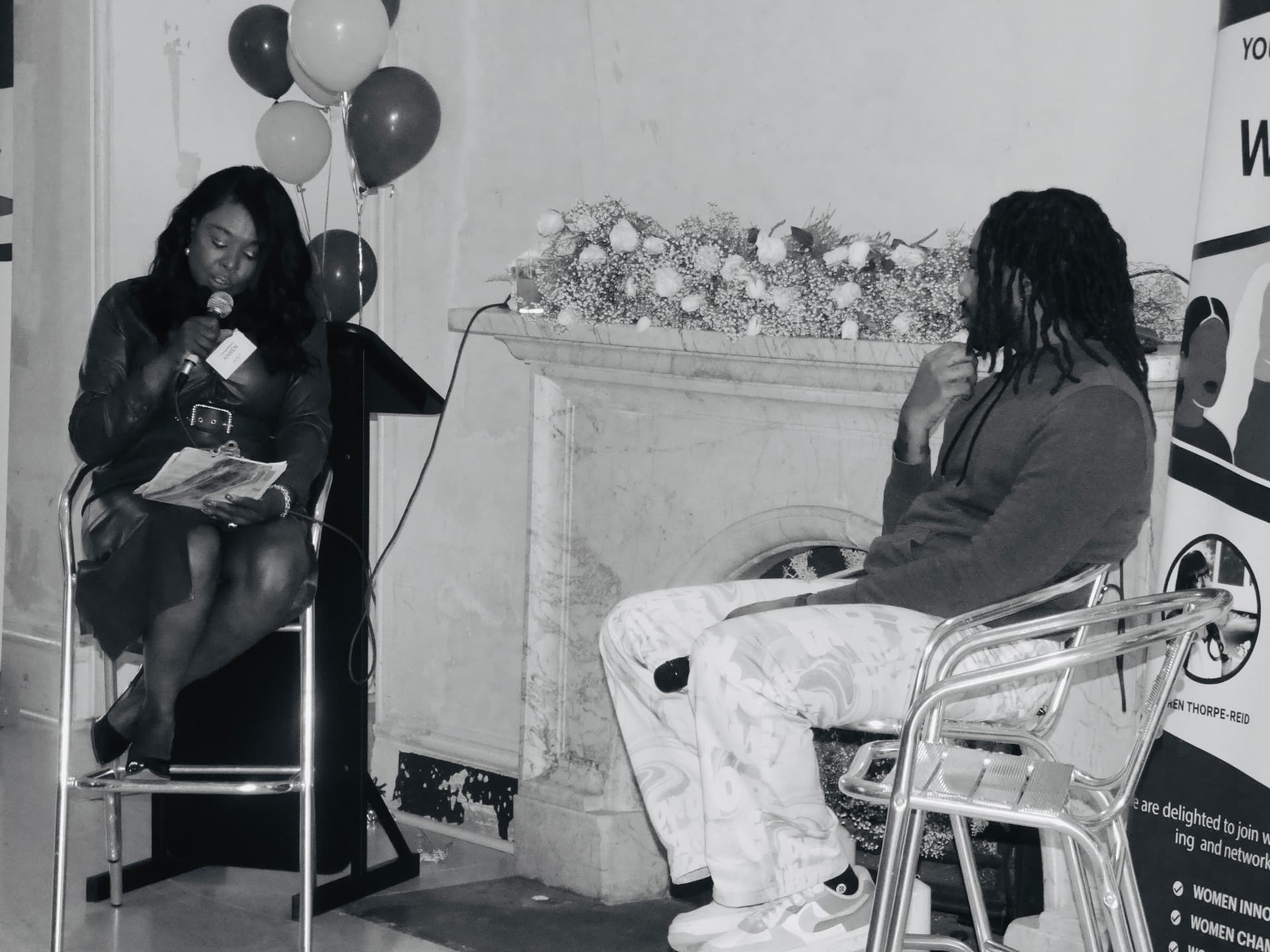 Karen Thorpe-Reid hosting a fireside conversation on stage with a guest