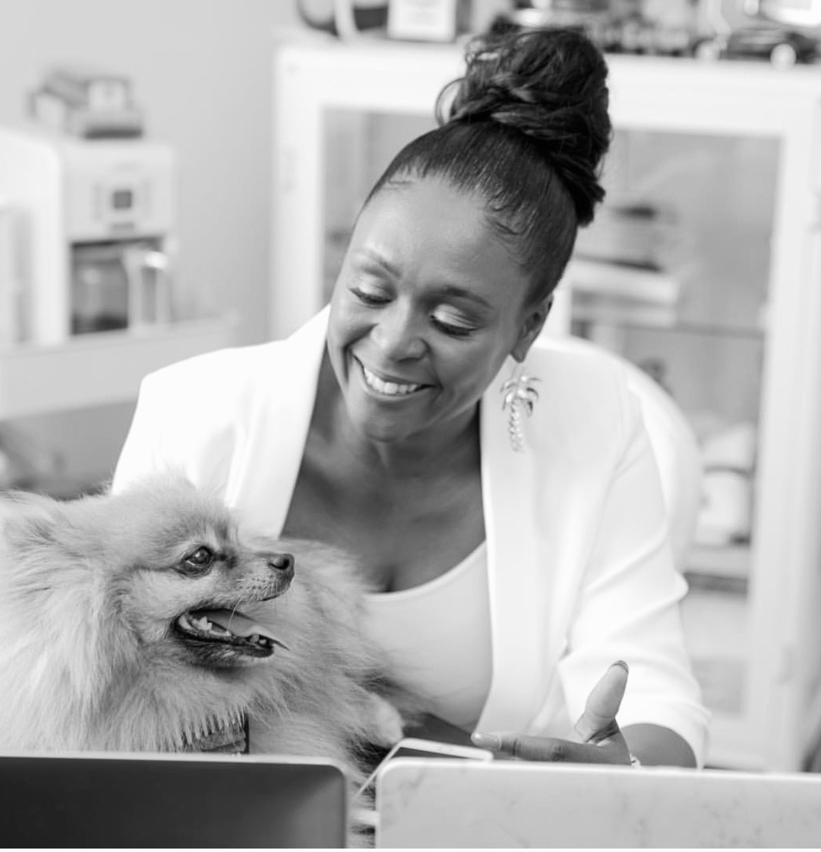 Karen Thorpe-Reid working at her desk, smiling beside her dog
