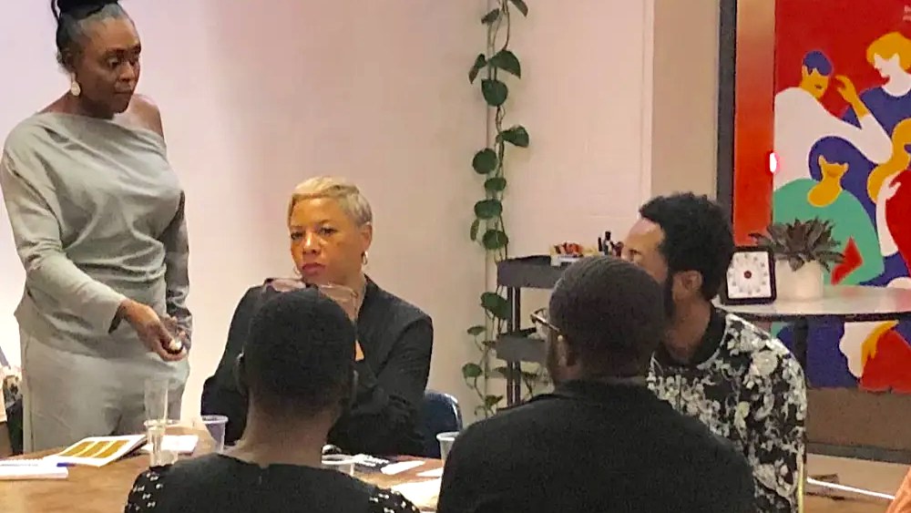 A small group of leaders in candid conversation around a table